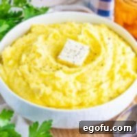 Velvety Stovetop Mashed Potatoes 12 Close up looking at a bowl of Stovetop Mashed Potatoes, garnished beautifully.