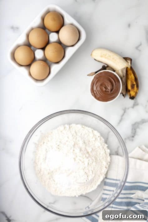 A mixing bowl filled with the dry ingredients: flour, baking soda, baking powder, and salt, ready for whisking.