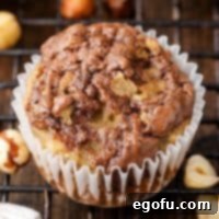 A close-up view of a Nutella Swirl Banana Muffin in its wrapper, perfectly baked and ready to be enjoyed.
