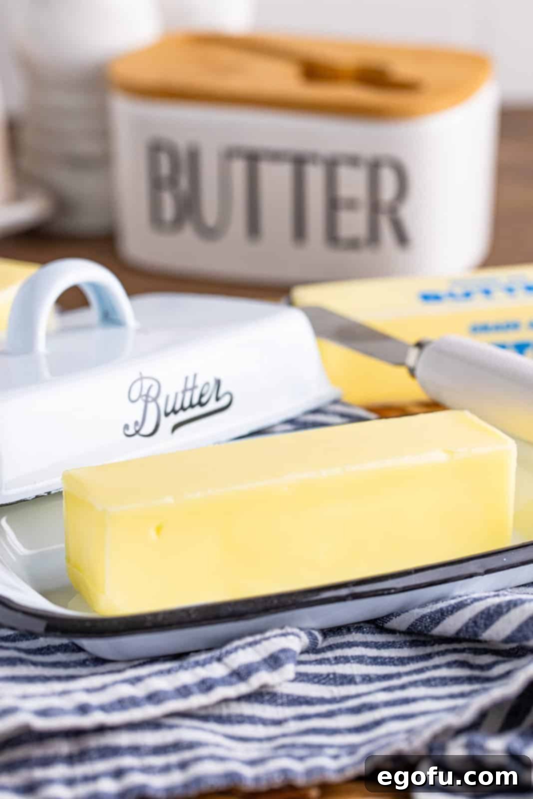 A stick of butter sitting in a butter tray, gradually softening at room temperature.