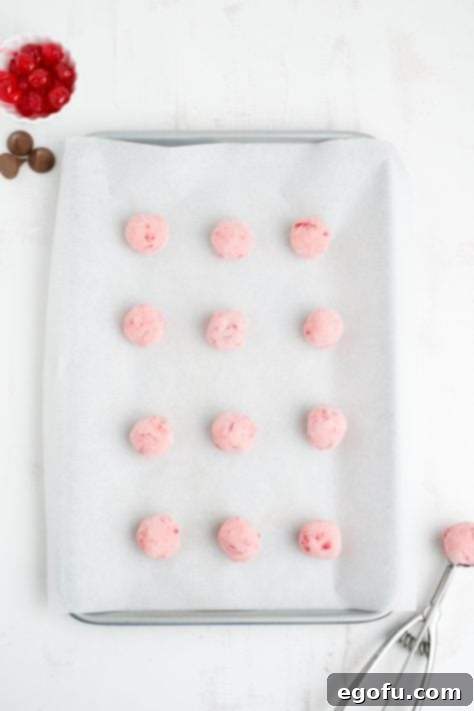 Sakura Bloom Bites 14 Cherry Blossom Cookie dough balls on a parchment lined baking sheet.