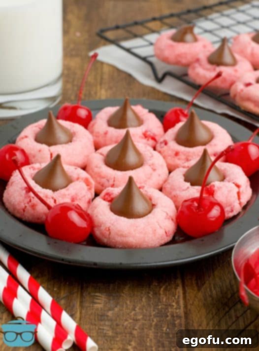 Sakura Bloom Bites 17 A plate of Cherry Blossom Cookies with a few cherries around the cookies on the plate.