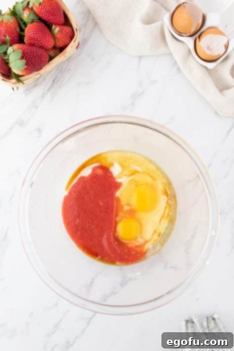 Decadent Strawberry Cake Bites 13 A bowl with butter, oil, sugar, eggs, strawberry jell-o powder, and vanilla extract.