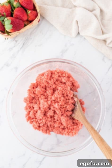 Decadent Strawberry Cake Bites 17 Softened cream cheese and strawberry cake crumbs mixed together in a bowl.