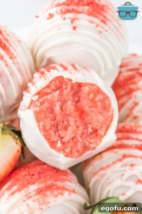 Decadent Strawberry Cake Bites 20 An open Strawberry Cake Ball sitting with a few others.