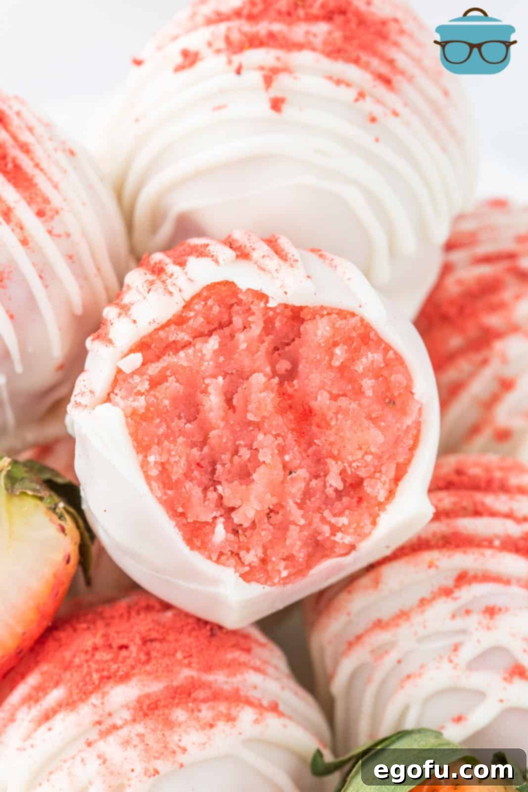 Decadent Strawberry Cake Bites 9 An open Strawberry Cake Ball sitting with a few others.