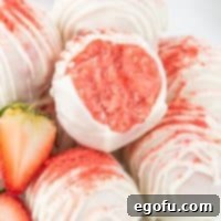 Decadent Strawberry Cake Bites 10 Closely looking at a Strawberry Cake Ball that someone has bitten into.