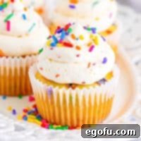 Festive Confetti Cupcakes 11 Close up looking at a homemade Funfetti Cupcake with frosting in a wrapper, perfectly baked and decorated.