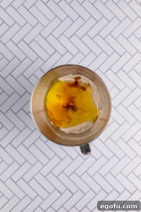 Festive Confetti Cupcakes 13 Vanilla extract and egg whites added to batter in bowl, mixing smoothly.