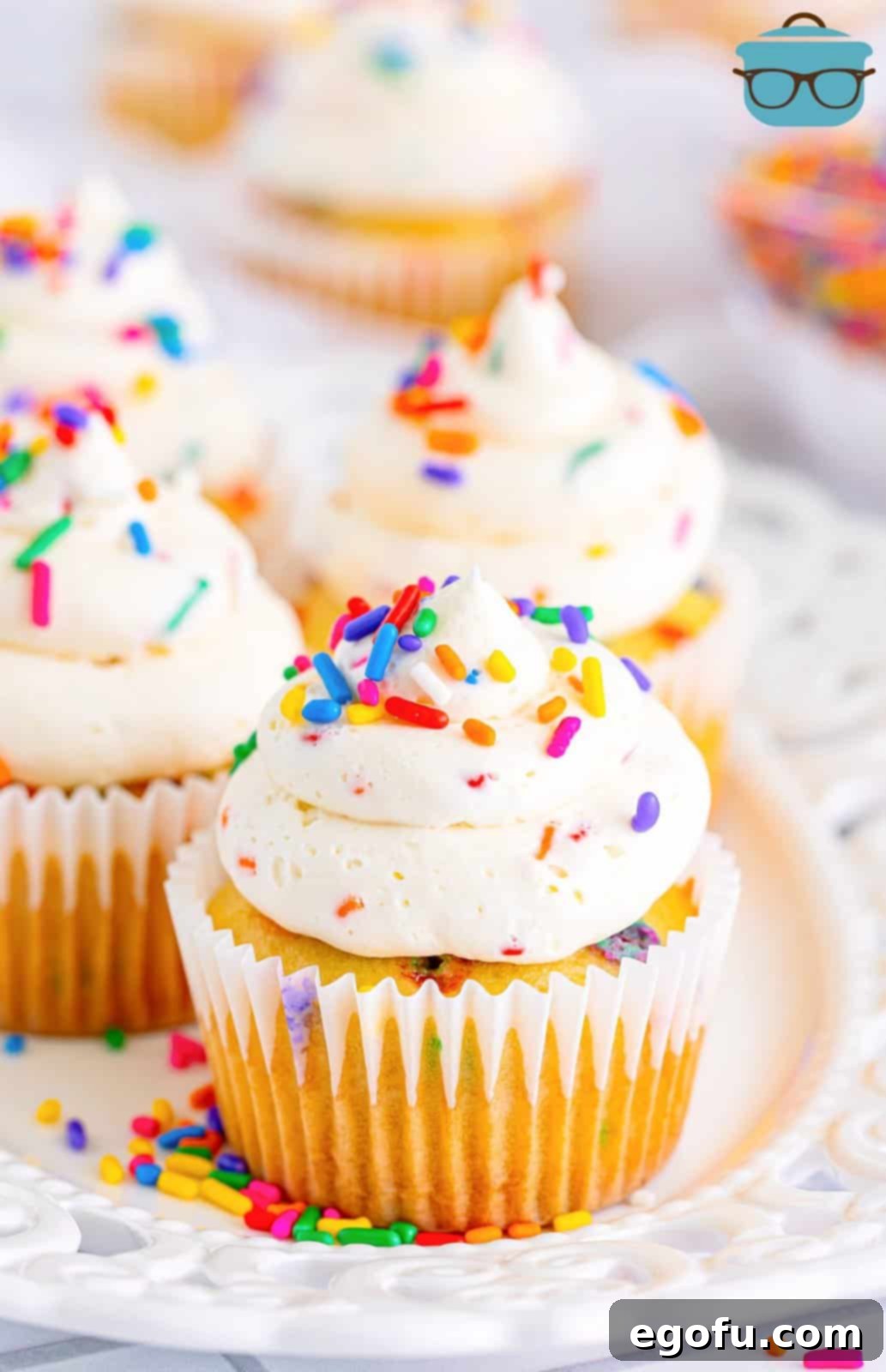Festive Confetti Cupcakes 10 A few homemade Funfetti Cupcakes, beautifully frosted with vanilla buttercream and adorned with sprinkles, artfully arranged on a dessert plate, ready to be enjoyed.