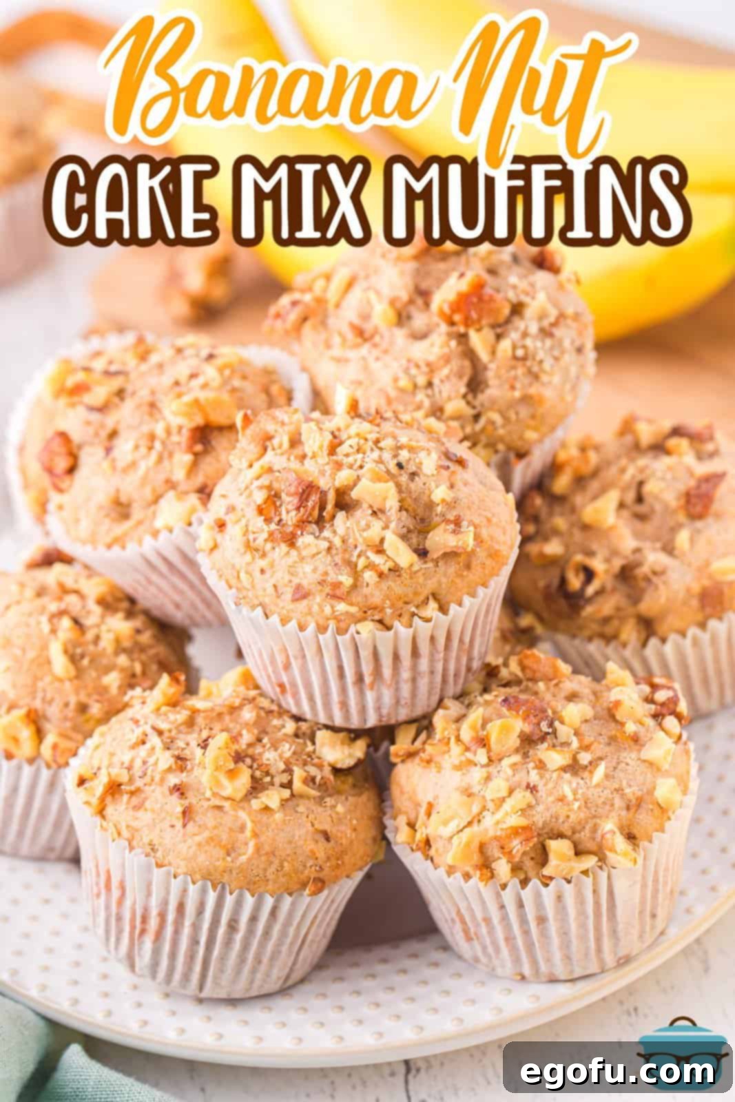 A pile of freshly baked Banana Nut Cake Mix Muffins sitting on a white serving plate.