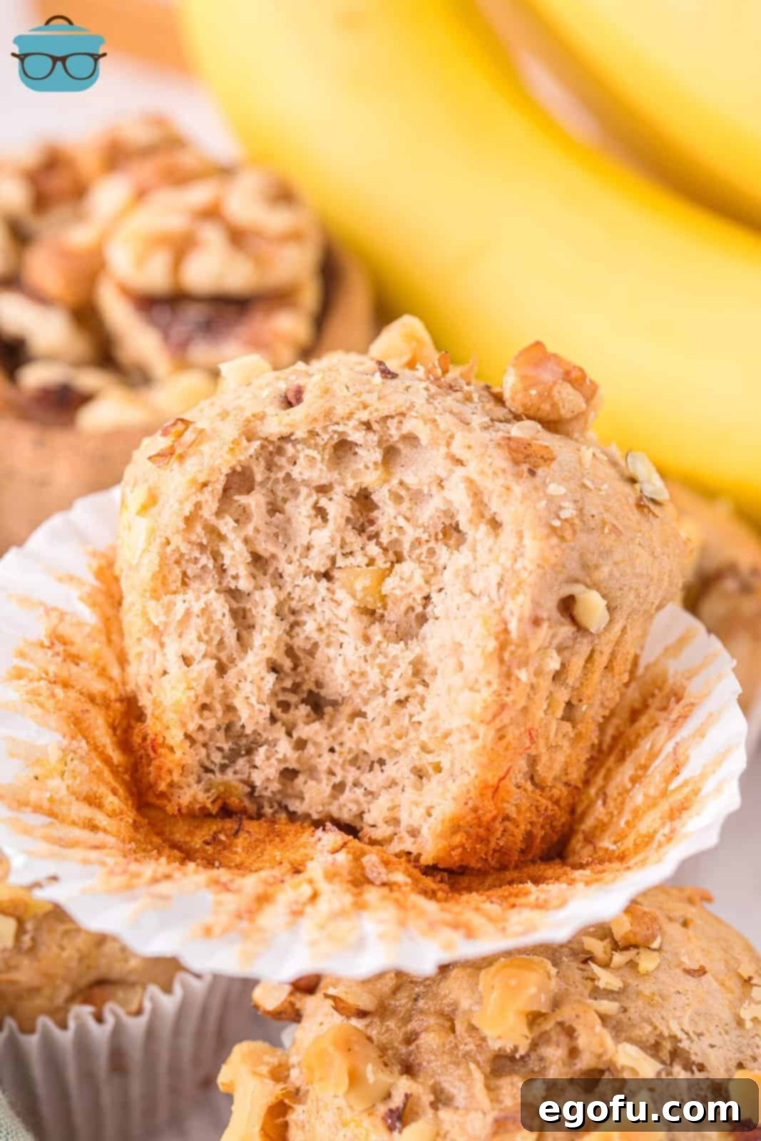 A Banana Nut Cake Mix Muffin with the wrapper peeled down and a bite missing.