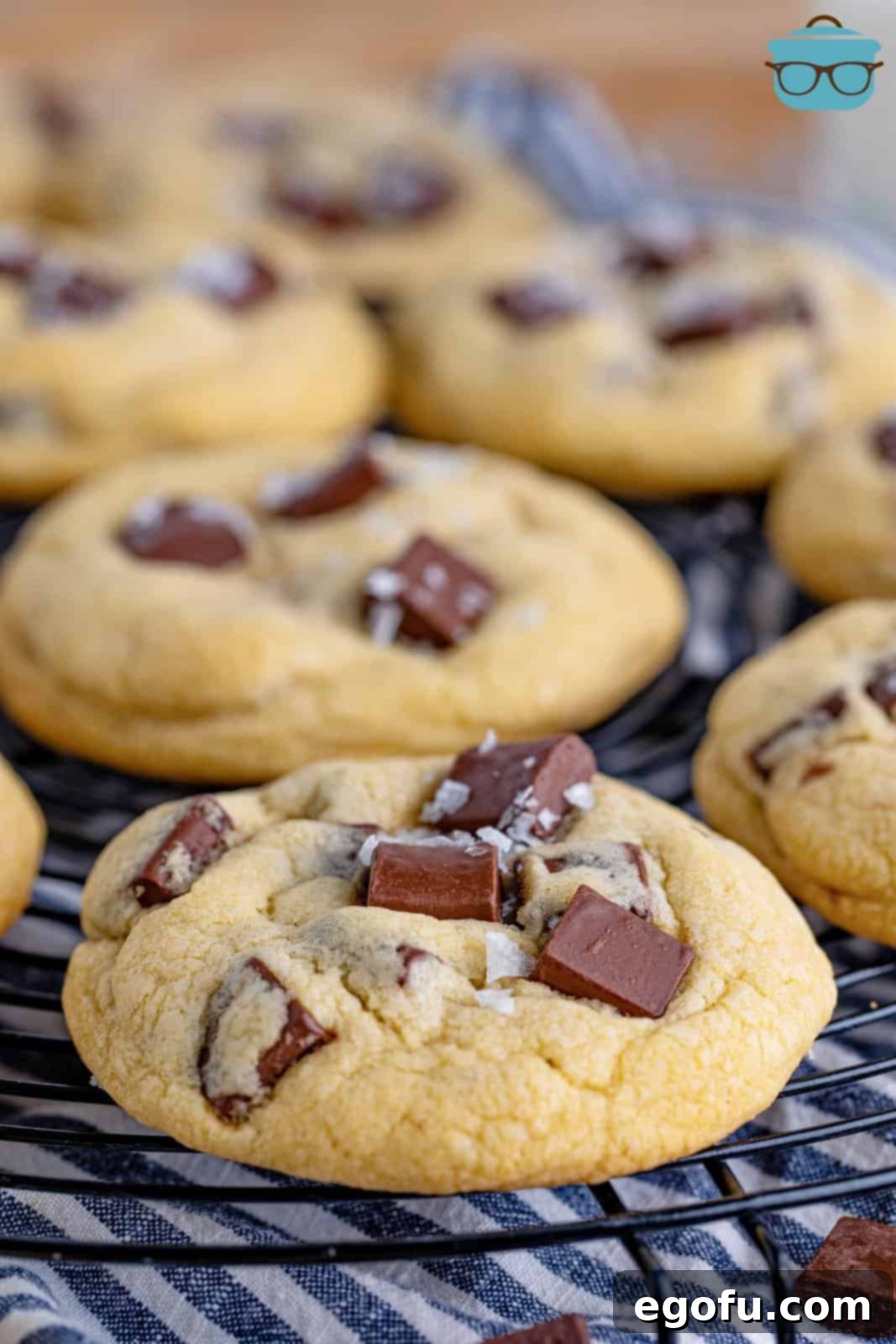 Warm, golden-brown chocolate chunk cookies on a wire cooling rack, showcasing their thick, chewy texture and abundant chocolate pieces, ready to be enjoyed.
