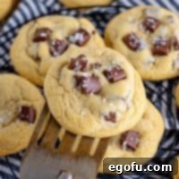 A few Chocolate Chunk Cookies, with a spatula lifting the top cookie, showcasing their enticing texture and melted chocolate.