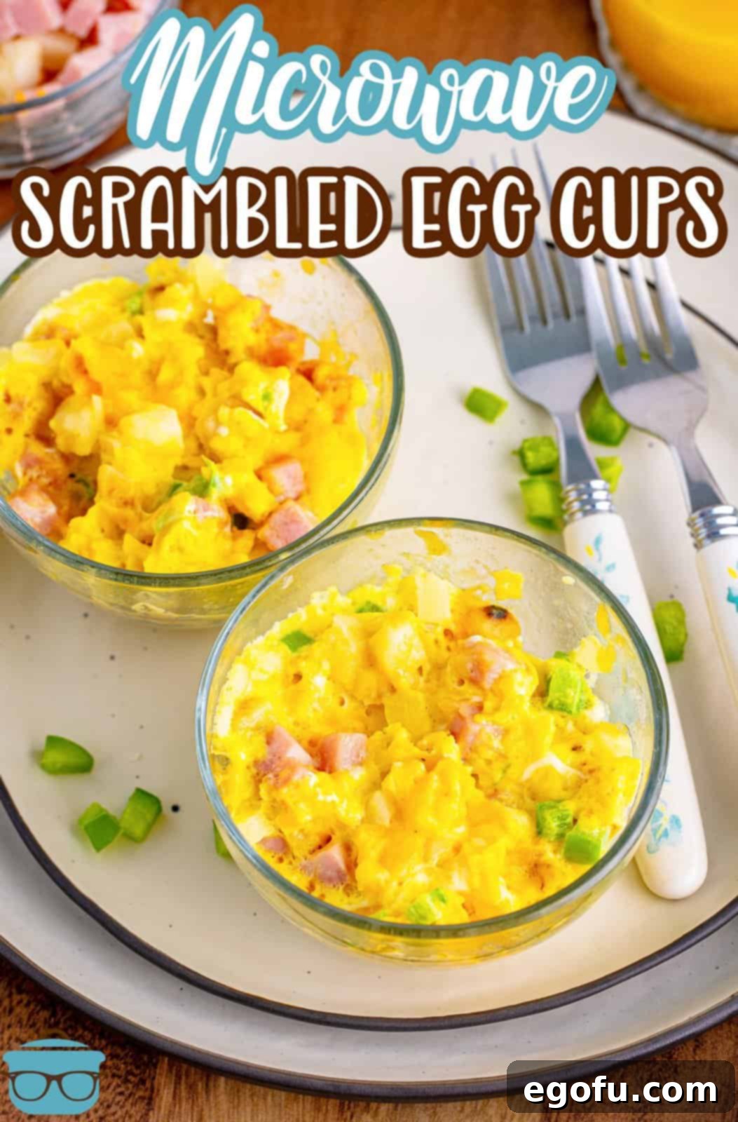 Looking down on two bowls of Microwave Scrambled eggs with bacon, pepper, and onion, garnished and ready to serve.