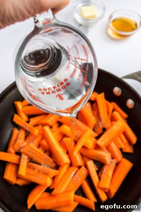 Water added to the carrots in a skillet.
