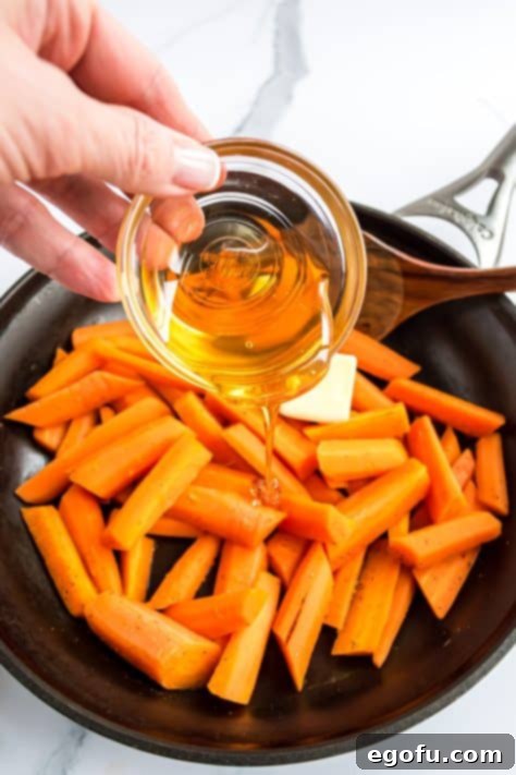 Butter and honey being added to the carrot mixture in a skillet.