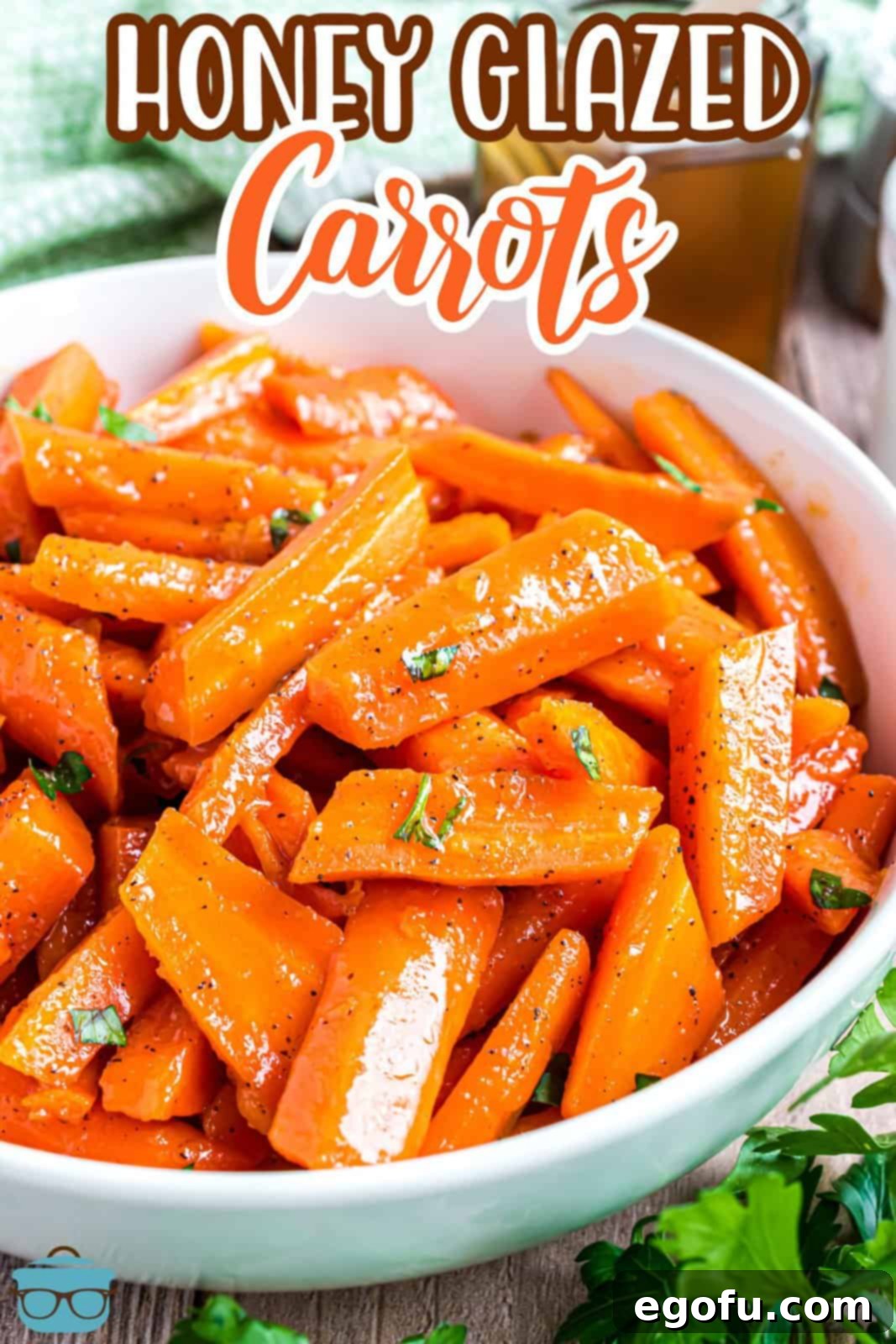 A large white serving bowl brimming with glistening Honey Glazed Carrots, ready to be served.