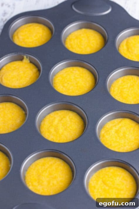 Golden Corn Muffins 12 A muffin pan with the wells filled with Cornbread Muffin batter.