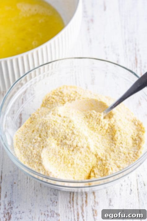 Golden Corn Muffins 10 A mixing bowl with cornmeal, flour, baking powder, and salt.