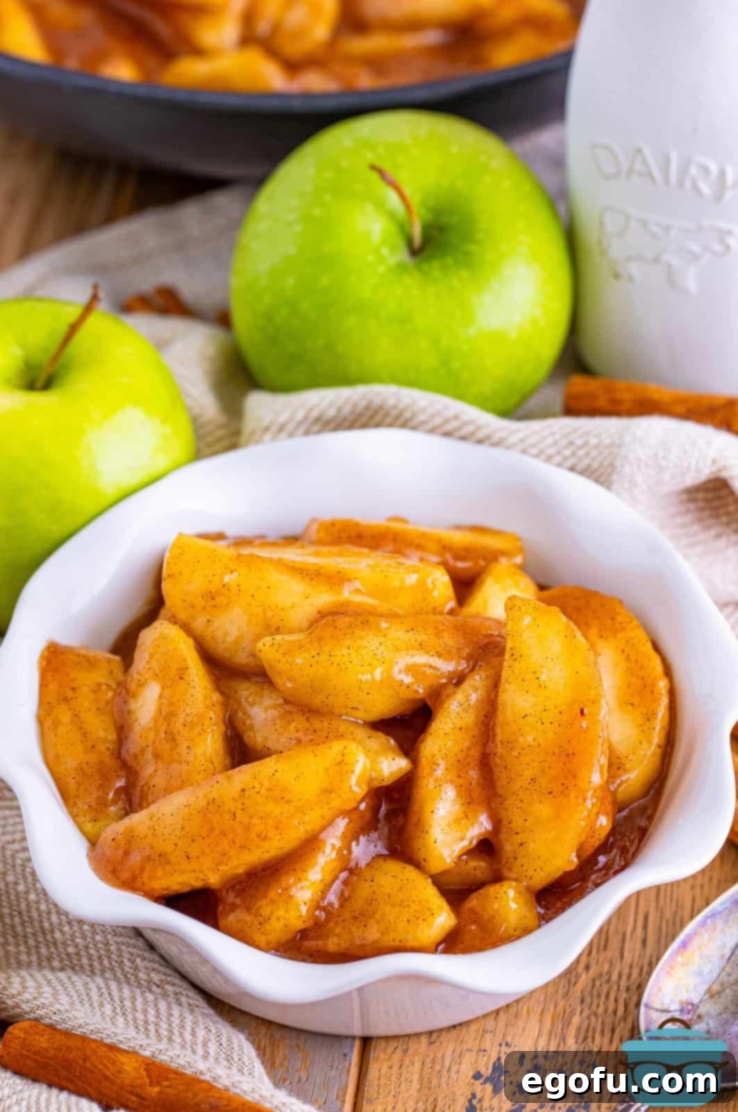 A small white bowl filled with perfectly cooked Southern Fried Apples, glistening with their sweet, spiced glaze.