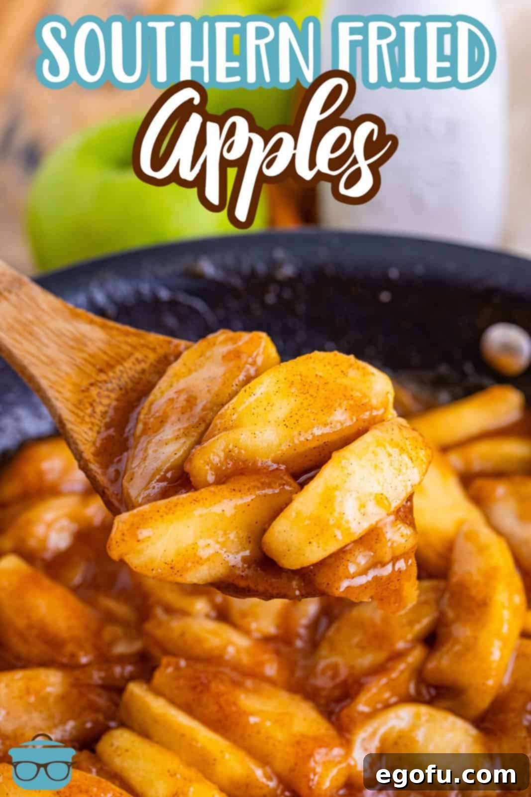 Southern Fried Apples simmering in a large cast-iron skillet, with a wooden spoon scooping out a generous portion.