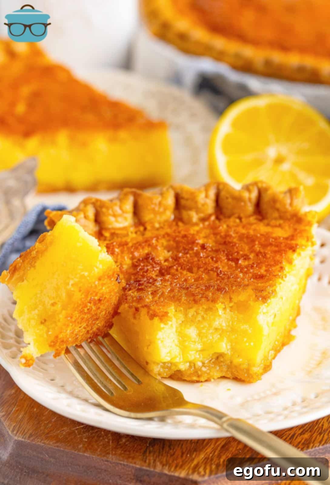 A perfect slice of Buttermilk Pie, with a fork holding a bite, highlighting its soft texture.