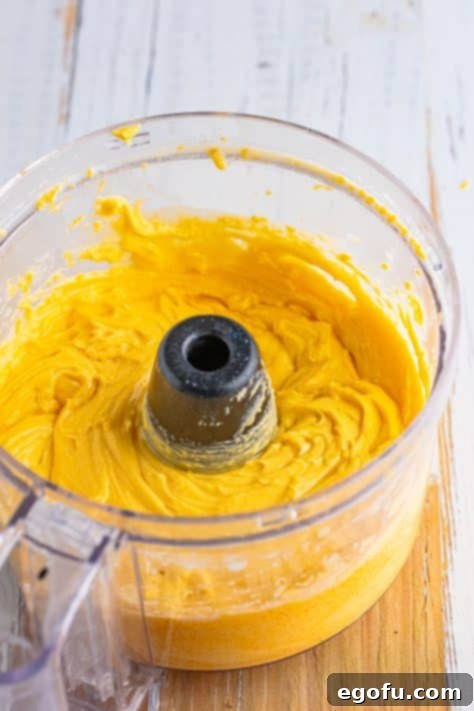 A food processor blending the cheese mixture to a smooth consistency.
