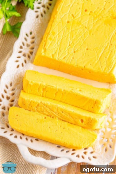 A top-down view of a fully set block of Homemade Velveeta cheese with slices already cut.