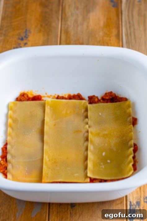 Cozy Lasagna Dinner for Two 18 Three lasagna noodles on top of sauce in a dish.