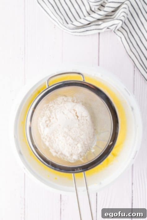 Flour being sifted into a cake batter.