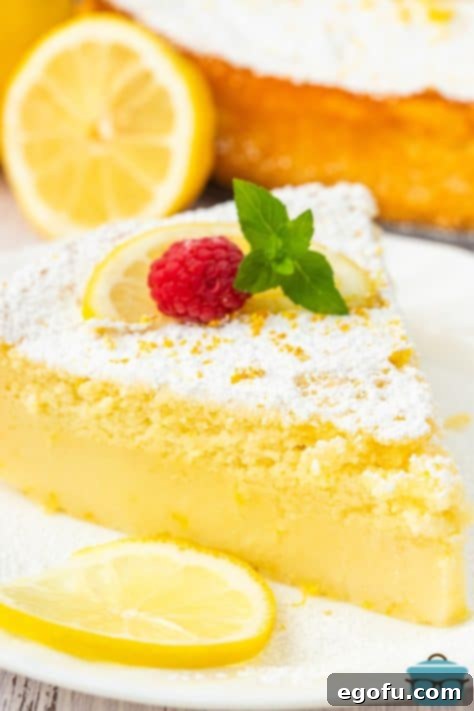 Closely looking at a slice of Lemon Magic Cake on a white dessert plate.