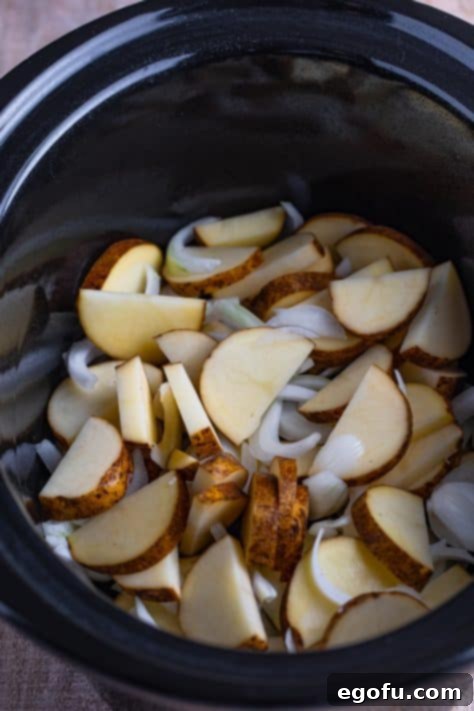 Easy One-Pot Pork Chops and Potatoes for Two 10 Sliced potatoes and onions in a Crock Pot.