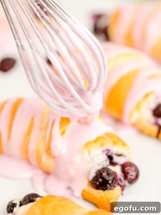 drizzling blueberry icing over crescent rolls.