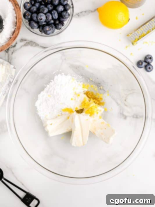 cream cheese, powdered sugar and lemon zest in a bowl.
