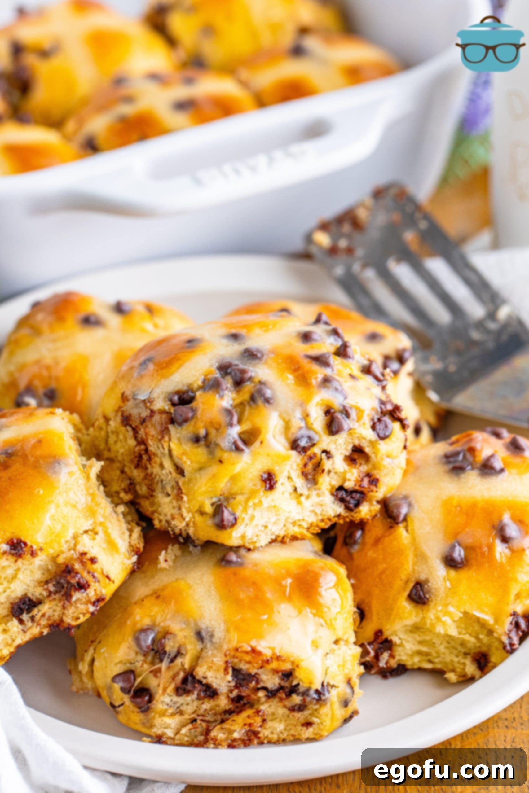 Indulgent Chocolate Hot Cross Buns 2 A plate with a pile of Hot Cross Buns, featuring a prominent cross and mini chocolate chips.