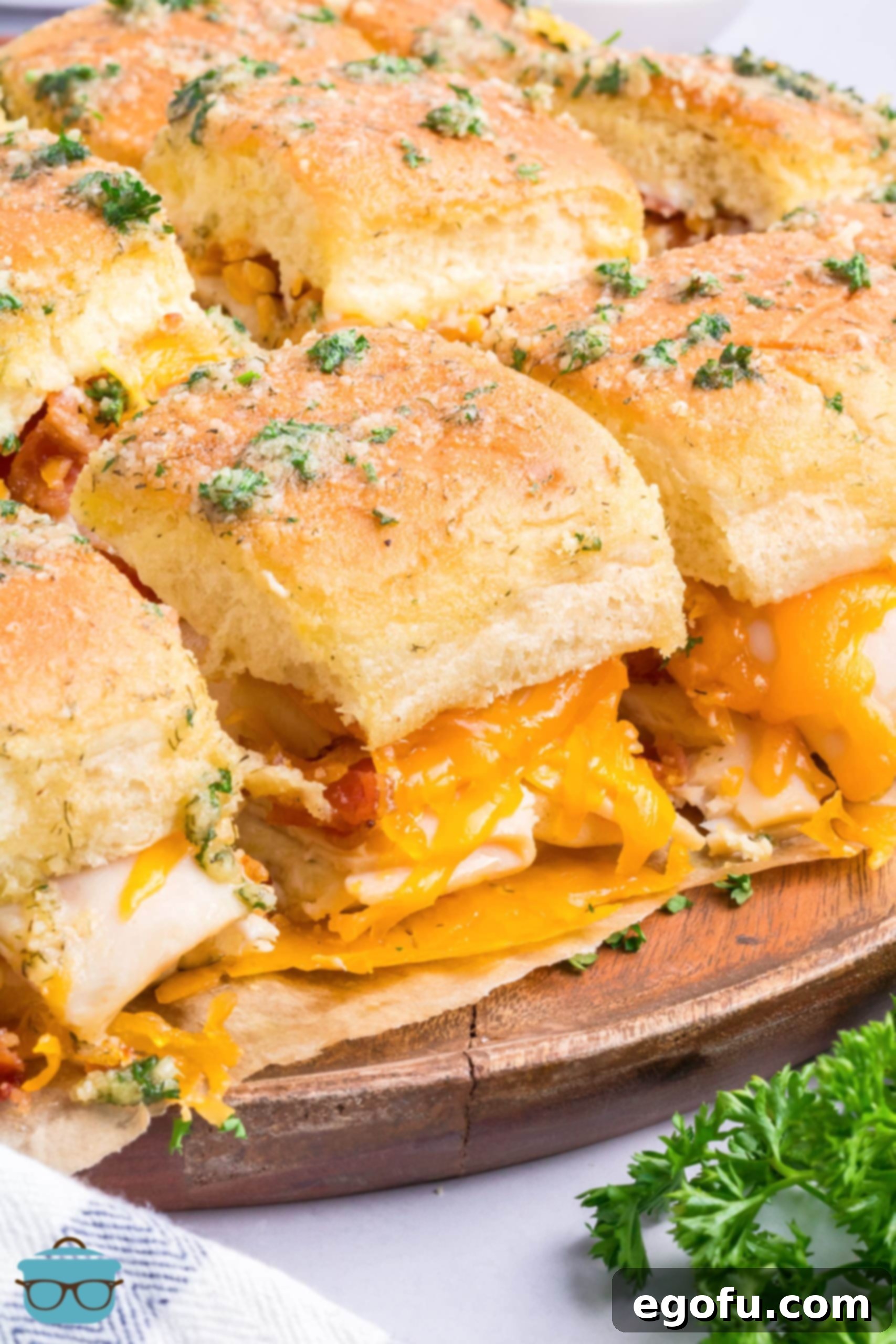 A serving tray of Chicken Bacon Ranch Sliders, garnished with fresh parsley.