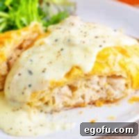 A Chicken Wellington with a slice missing on a plate.