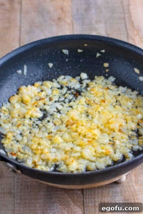 Butter and onions cooking in a skillet.