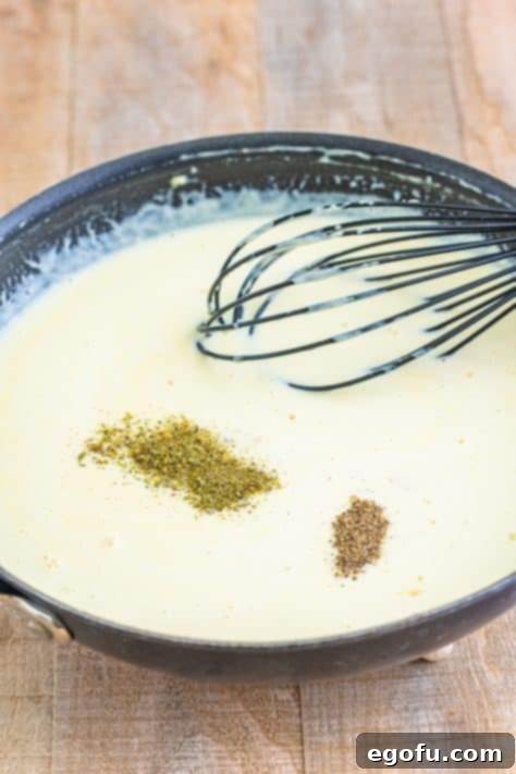 seasonings added to cream sauce with a whisk.