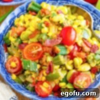 A blue bowl with a large side of Succotash, garnished with crispy bacon.