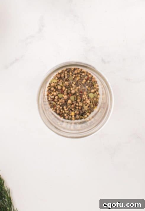 Pickling spices in the bottom of a pint sized mason jar.