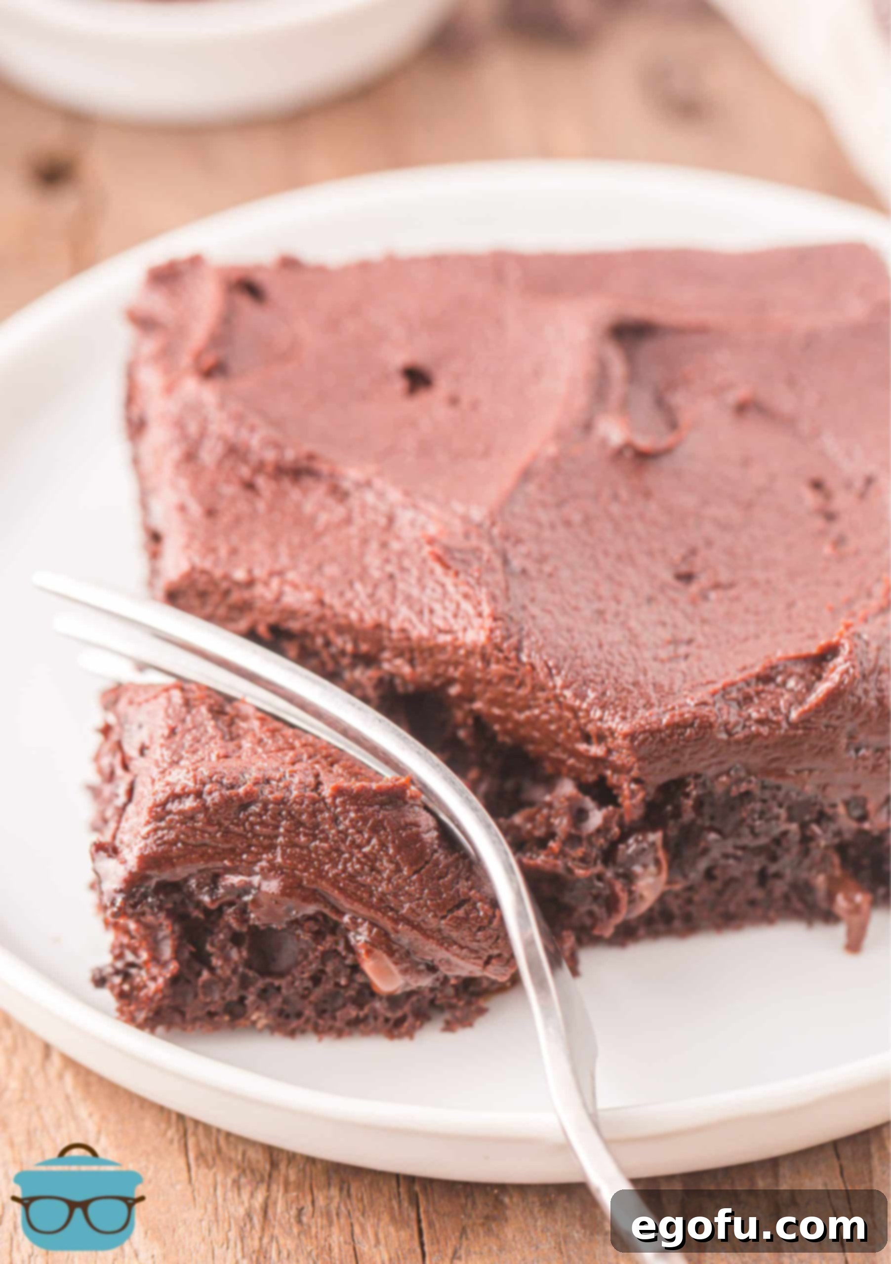 A fork pressing into a generous slice of Chocolate Sheet Cake, showing its delightful texture and rich frosting.