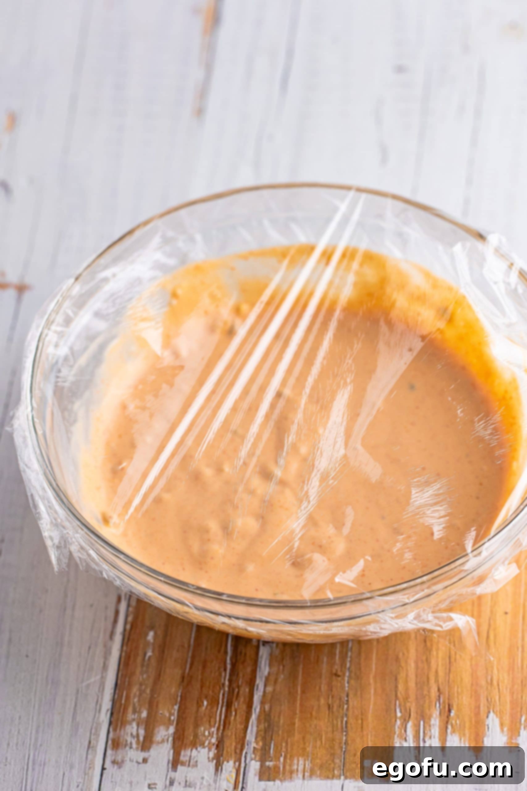 Thousand Island Dressing in a bowl covered with plastic wrpa.