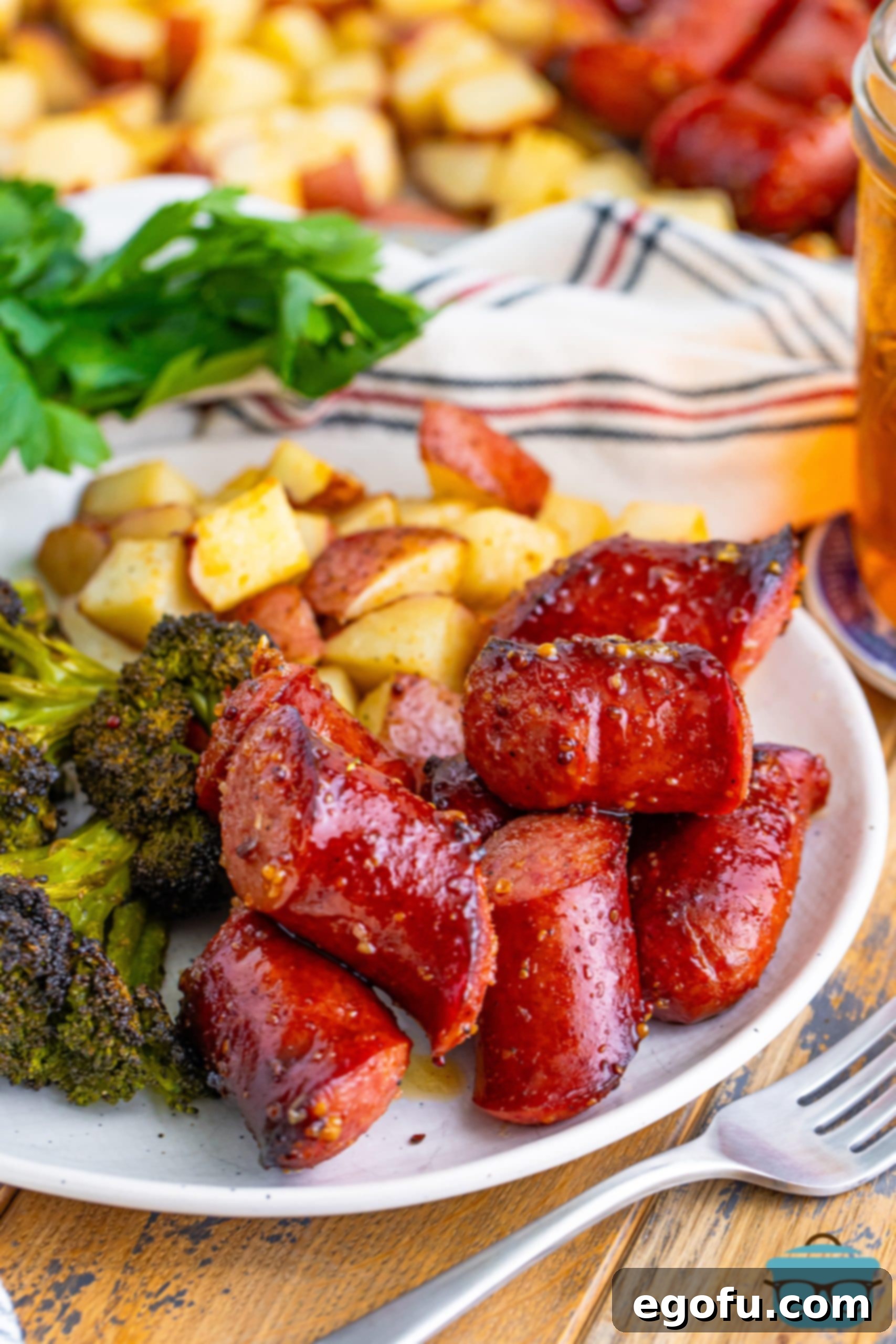 A plate with Kielbasa and sides on it, showcasing the deliciousness of a sheet pan dinner.