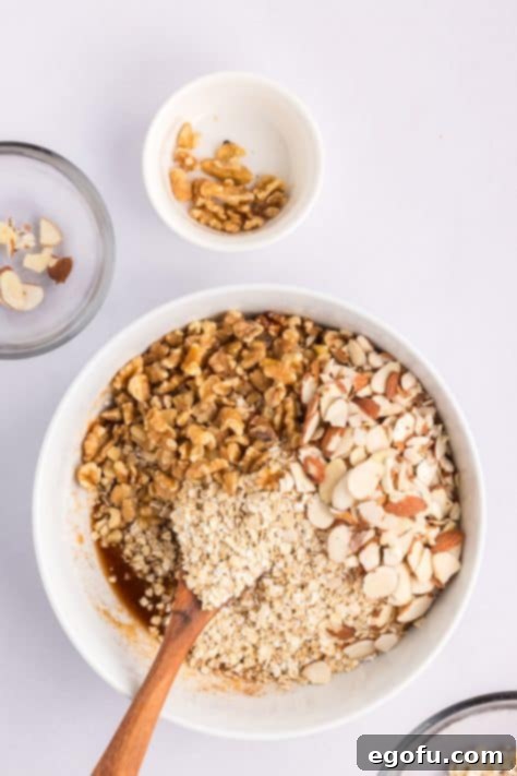 A bowl with cooking oats, sliced almonds, and chopped walnuts added.