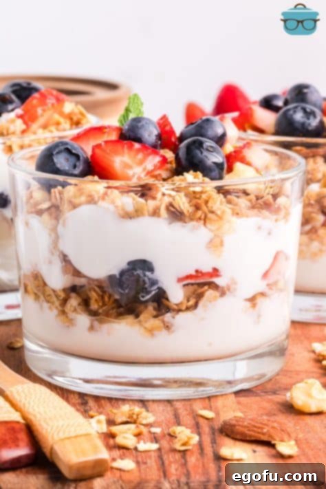 A beautifully layered Yogurt Parfait in a cup, ready to be eaten.