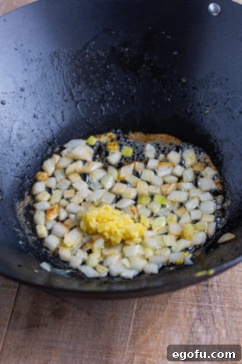 Garlic, butter, and onions in a wok.