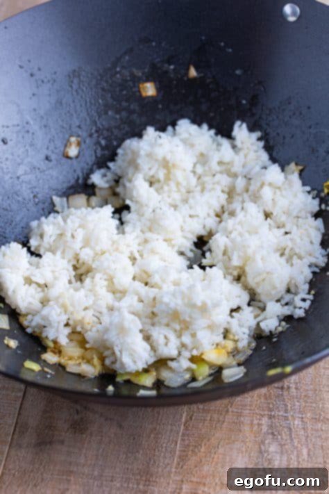 Rice being added to a wok.