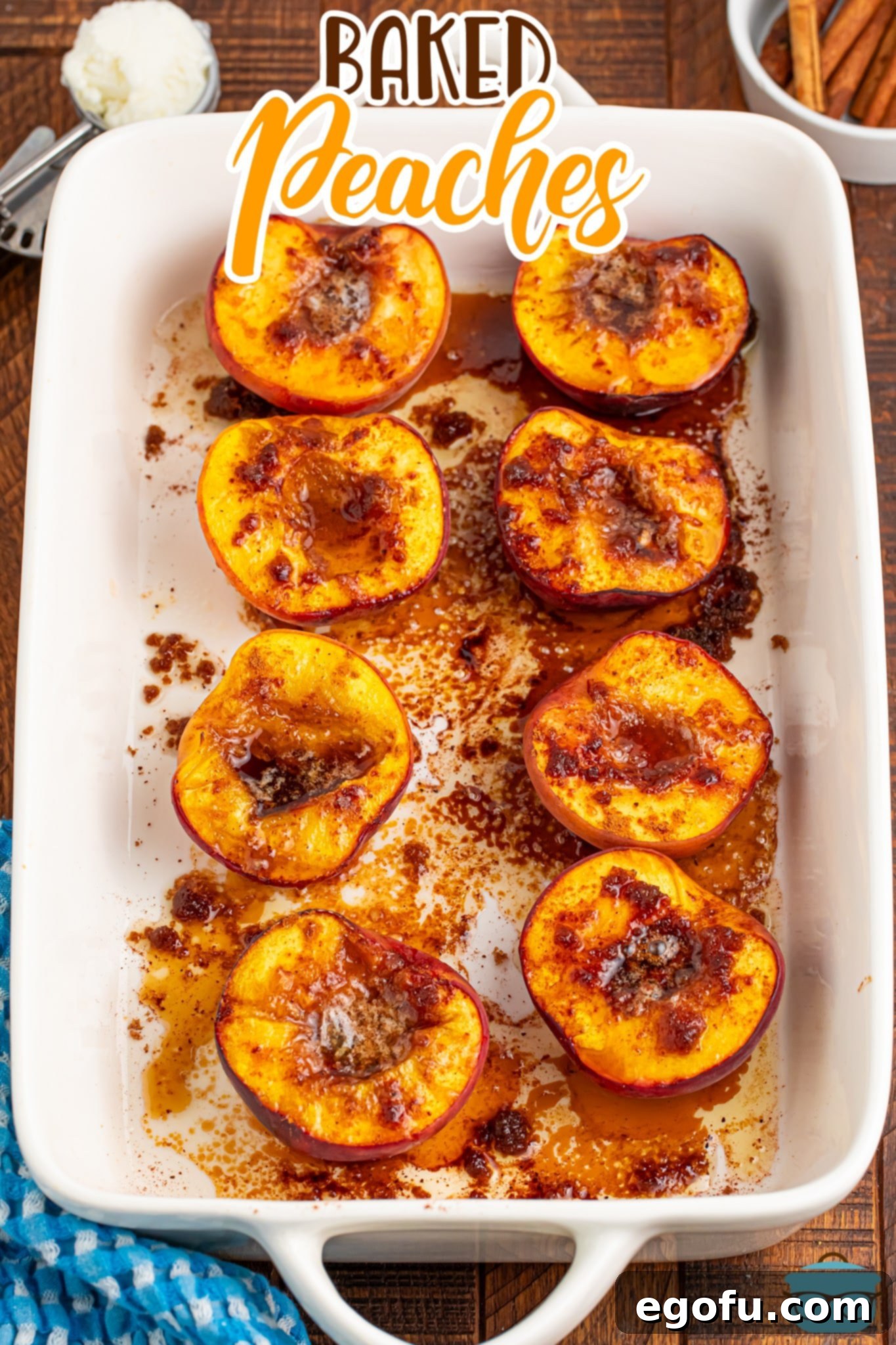 Eight Baked Peaches neatly arranged in a rectangular baking dish, showcasing their golden-brown tops and rich sauce.
